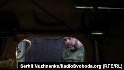 Украинский военнослужащий бригады НГУ "Кара-Даг" осматривает захваченный под Покровском российский БТР-82, 9 октября 2024 года