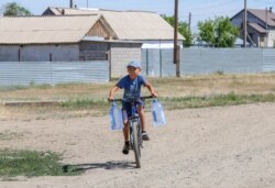 Велосипед мініп, су тасып жүрген бала. Қызылсуат ауылы, Ақмола облысы. 10 маусым 2020 жыл.