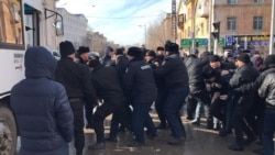 Полиция көшеден ұстаған адамдарды көлікке күштеп салып жатыр. Ақтөбе, 22 ақпан 2020 жыл.