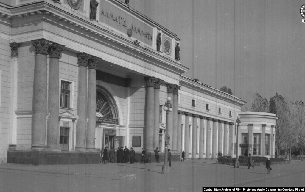 Алматы қаласы теміржол вокзалының ғимараты. 1950 жыл (сол жақта). Верныйда (1921 жылға дейін қала осылай аталды) бұл ауданда зират болған. Құрылыс жүріп жатқан кезде зиратты тасқын шайып кетті. Ғимарат 1936-1939 жылдары салынды. Архитекторлары &ndash; Галкин мен Кудрявцев. 1977 жылы реконструкция жасалды. 2012 жылы толық жөндеуден өтті. Вокзалға келіп тірелетін көше атауы бірнеше рет өзгерді. Верный кезінде Старокладбищенская, 1933 жылы Сталин даңғылы, 1961 жылы Коммунистік даңғылы болды. Қазір Абылайхан даңғылы деп аталады. 