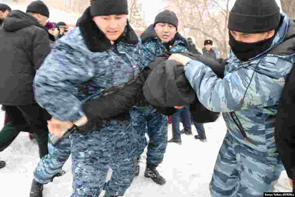 Арнайы жасақ наразылық белгіленген жерге келгендердің бірін әкетіп барады.&nbsp;